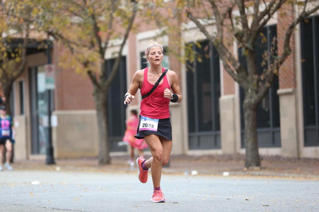 Woman tired running mile 5 of a 26.2 mile race