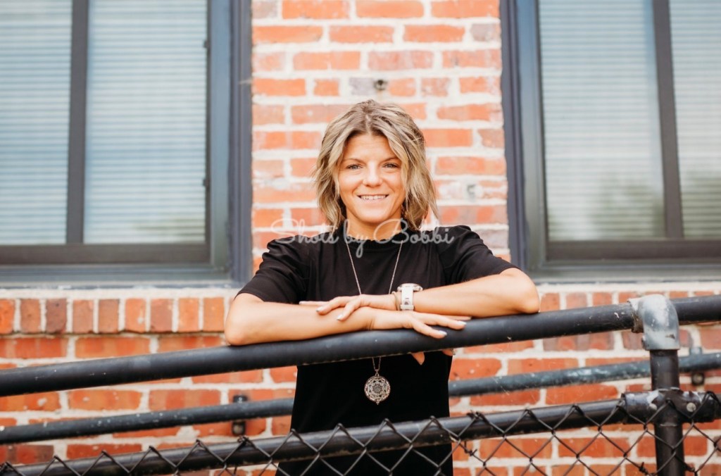 photo of Aubrey in front of brick building smiling